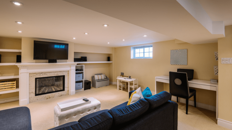 Finished basement living space with recessed lighting, fireplace, home office desk, and seating area designed for comfort and functionality